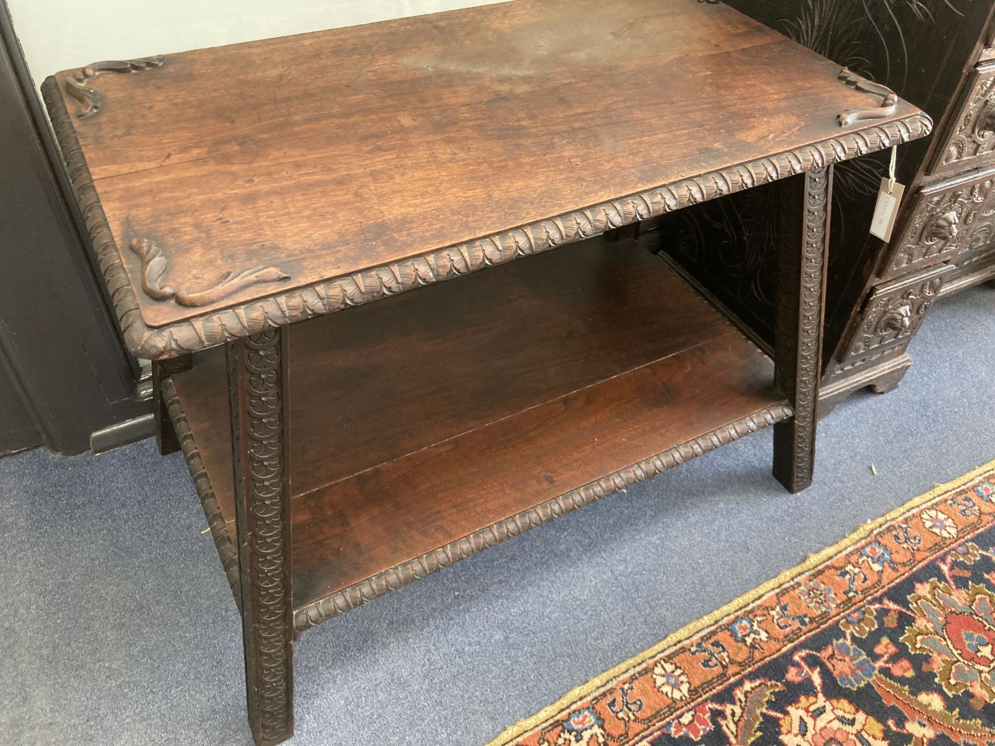 A rectangular carved hardwood two tier table, width 90cm, depth 56cm, height 64cm